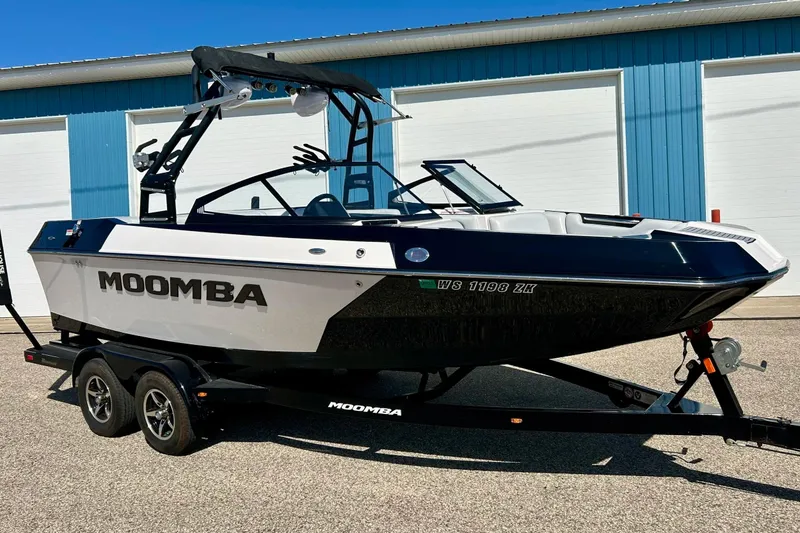 The Image of 2018 Moomba Helix boat on trailer, parked outside blue building. - 0