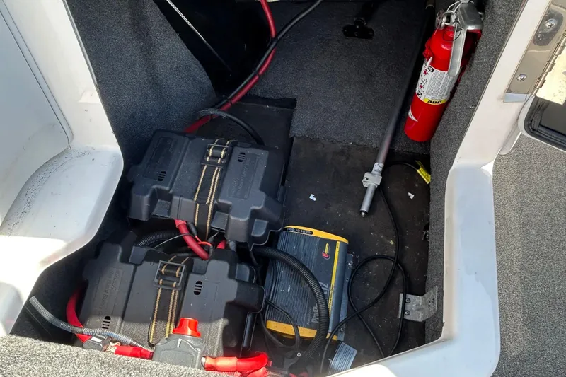 Slide: The Image of 2018 Moomba Helix boat storage area with batteries, charger, and fire extinguisher. - 27