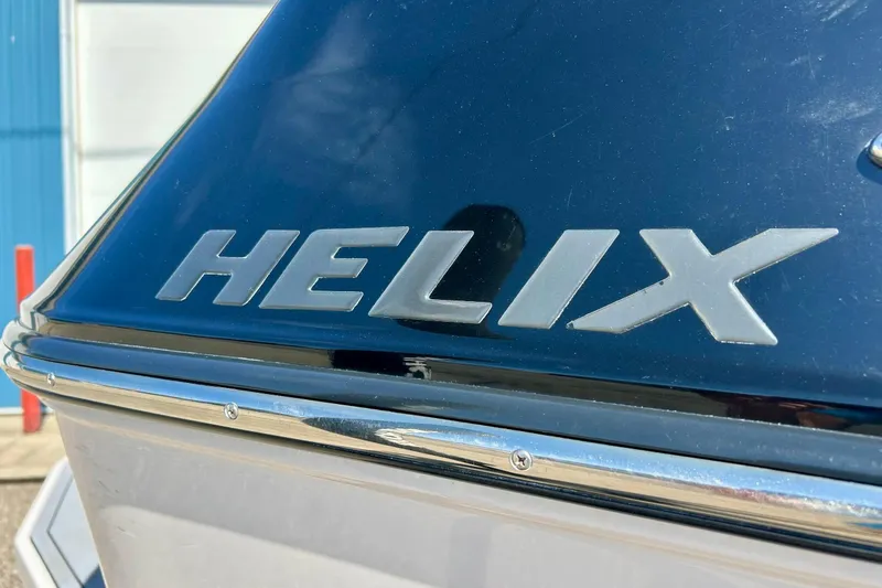 Slide: The Image of 2018 Moomba Helix boat logo on sleek black surface. - 5