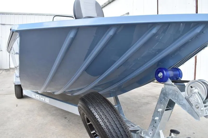 Slide: The Image of 2026 Lowe Roughneck RX2070 CC boat with a blue exterior and a mounted power outlet. - 13