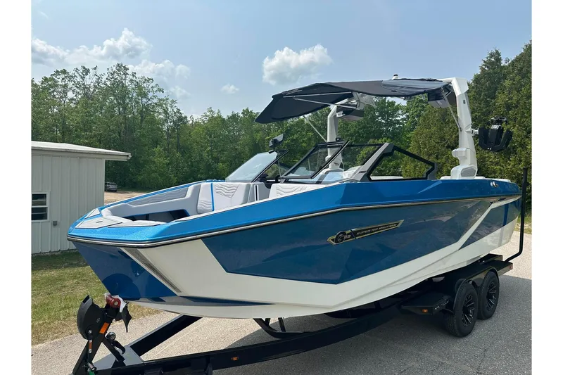 Slide: The Image of 2025 Nautique Super Air Nautique G23 boat in blue, parked on a trailer. - 1