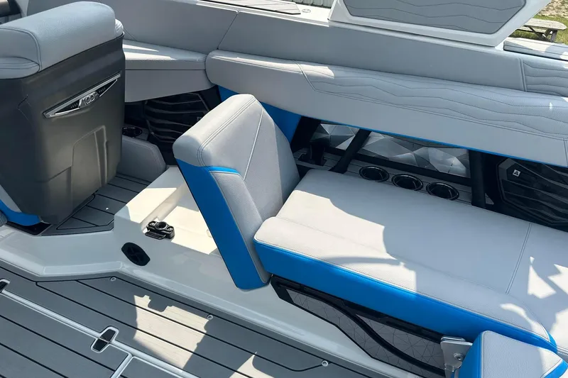 Slide: The Image of 2025 Nautique Super Air Nautique G23 interior with gray and blue seating, cup holders, and sleek design. - 14