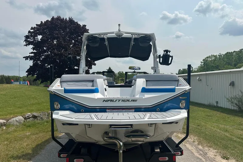 Slide: The Image of 2025 Nautique Super Air Nautique G23 boat, rear view, parked outdoors. - 2