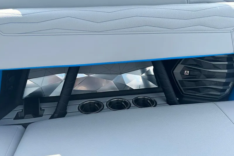 Slide: The Image of 2025 Nautique Super Air Nautique G23 interior with cup holders and speaker detail. - 20
