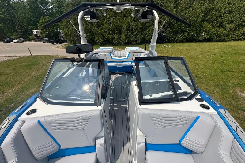 Slide: The Image of 2025 Nautique Super Air Nautique G23 boat interior with blue and white seating, open windshield. - 27