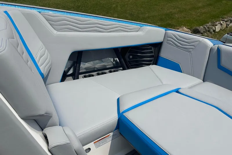 Slide: The Image of 2025 Nautique Super Air Nautique G23 interior seating with blue accents and cup holders. - 29