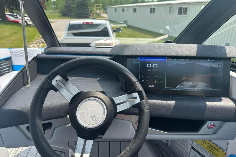 Slide: The Image of 2025 Nautique Super Air Nautique G23 dashboard with digital display and steering wheel. - 33