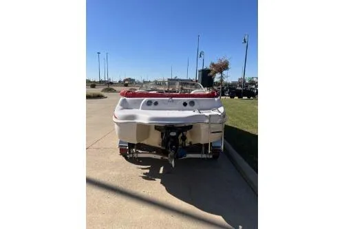 Slide: The Image of 2004 Tahoe Q-4 boat, rear view, parked on concrete under clear blue sky. - 6