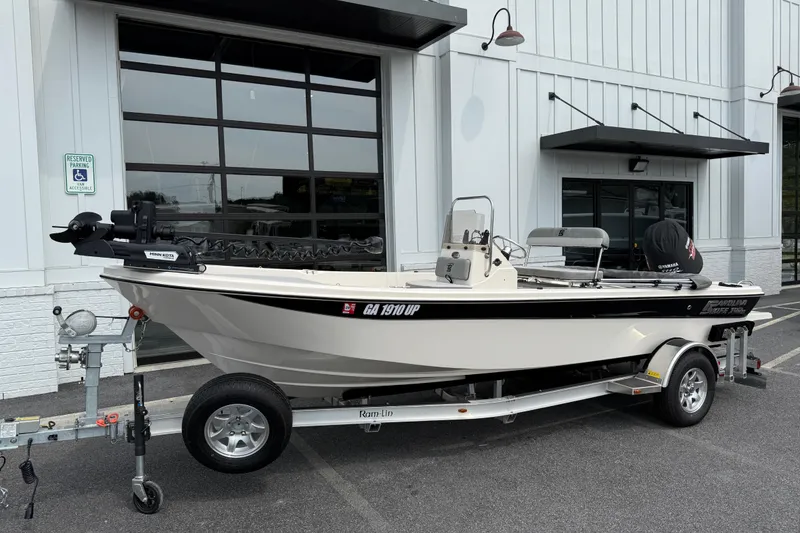 The Image of 2025 Carolina Skiff 192 JLS boat on trailer, parked outside a building. - 1