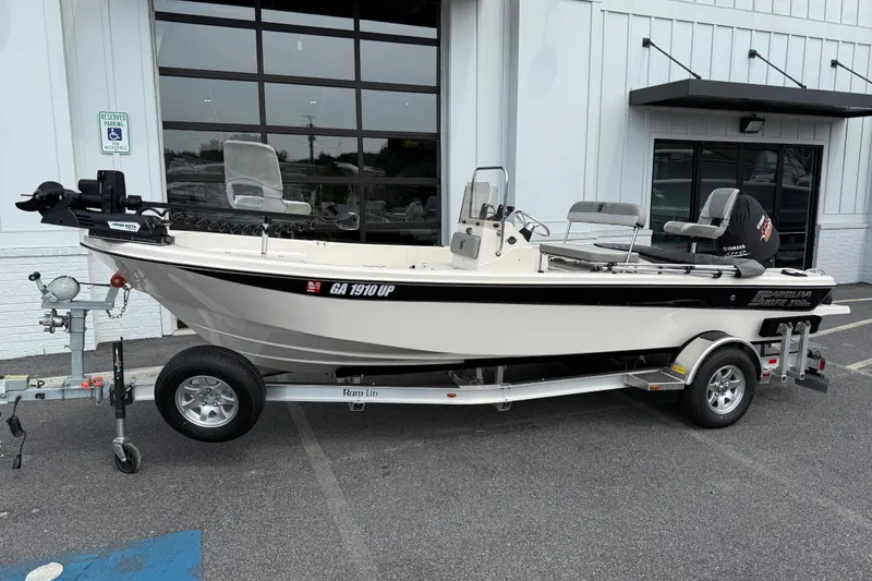 Slide: The Image of 2025 Carolina Skiff 192 JLS boat on trailer, parked outside a building. - 10