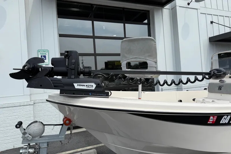 Slide: The Image of 2025 Carolina Skiff 192 JLS with Minn Kota Terrova motor, parked outside a building. - 11