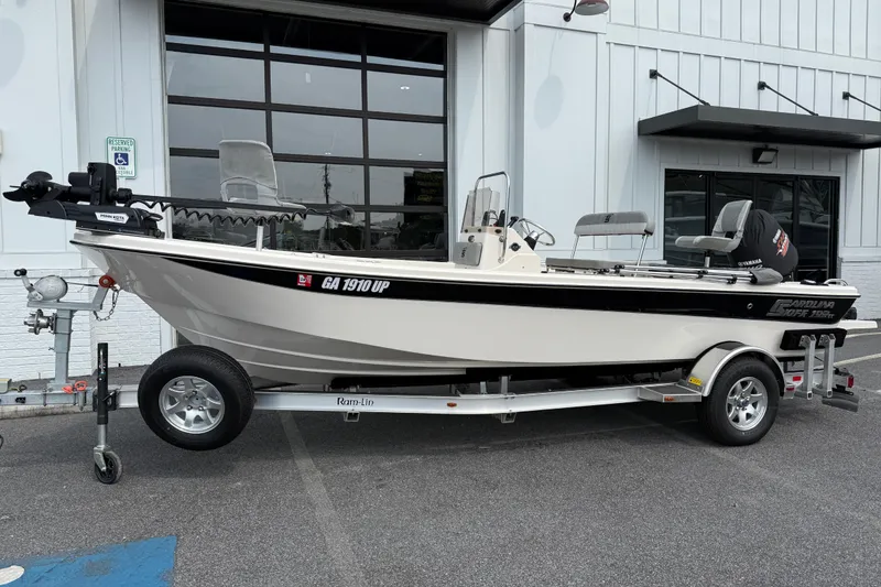 Slide: The Image of 2025 Carolina Skiff 192 JLS boat on trailer, parked outside a building. - 12