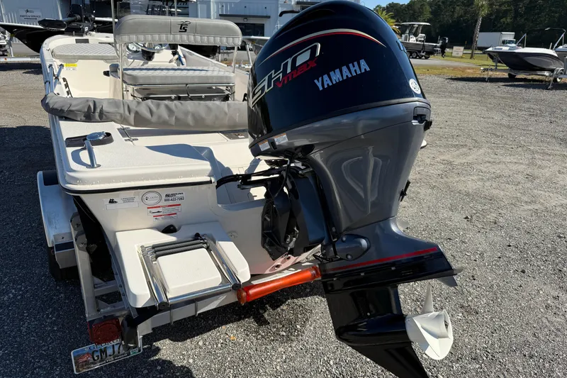Slide: The Image of 2025 Carolina Skiff 192 JLS boat with Yamaha outboard motor, parked on gravel. - 21