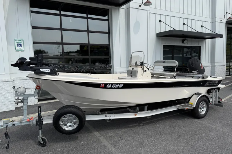 Slide: The Image of 2025 Carolina Skiff 192 JLS boat on trailer, parked outside a building. - 3