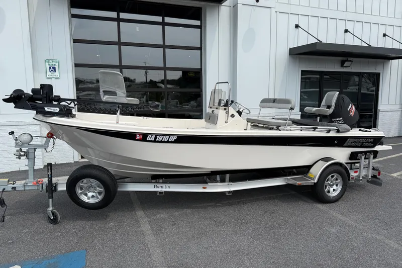 Slide: The Image of 2025 Carolina Skiff 192 JLS boat on trailer, parked outside a building. - 9