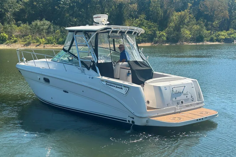 Slide: The Image of 2008 Sea Ray 290 Amberjack boat cruising on a calm lake with lush green shoreline. - 10