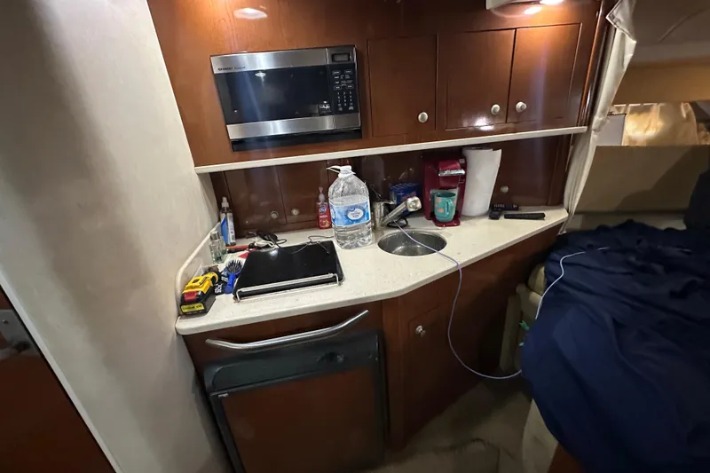 Slide: The Image of 2008 Sea Ray 290 Amberjack cabin with kitchenette, microwave, and storage cabinets. - 29