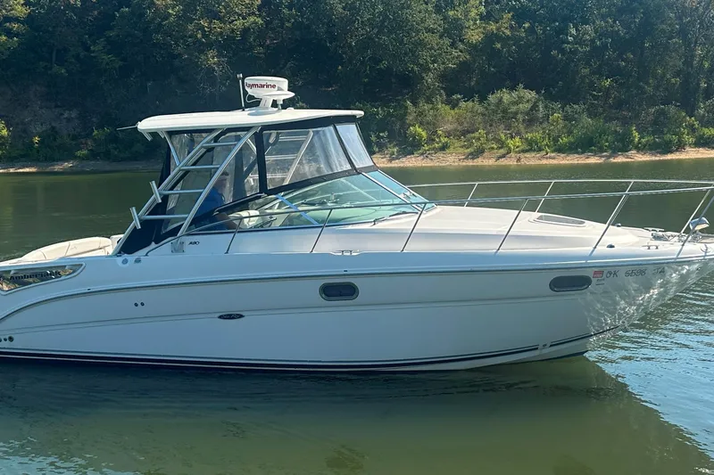 Slide: The Image of 2008 Sea Ray 290 Amberjack boat on calm water, surrounded by lush greenery. - 3