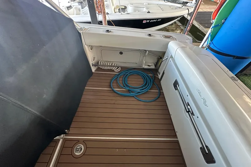 Slide: The Image of 2008 Sea Ray 290 Amberjack deck with coiled blue hose and teak flooring. - 34