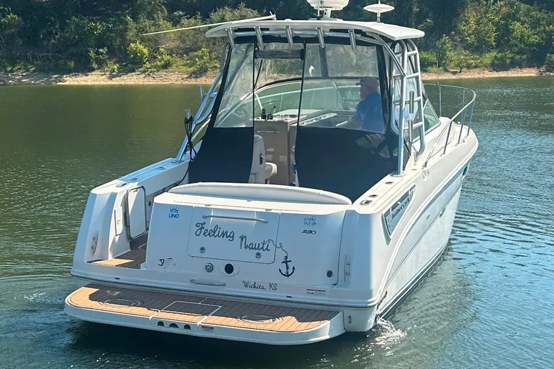 Slide: The Image of 2008 Sea Ray 290 Amberjack boat on water, rear view with "Feeling Nauti" name. - 6