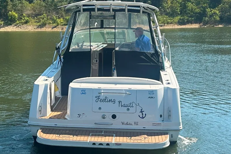 Slide: The Image of 2008 Sea Ray 290 Amberjack boat on water, rear view, with person at helm. - 7