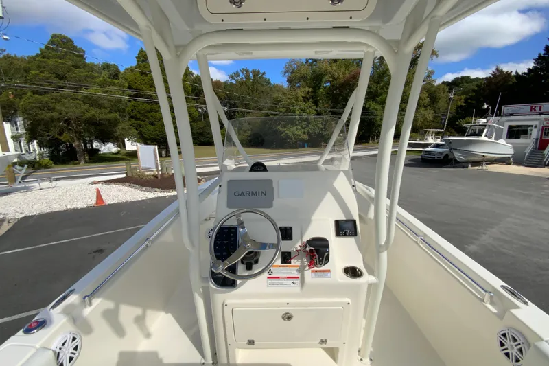 Slide: The Image of 2025 Cobia 220 Center Console boat with Garmin navigation system, parked outdoors. - 13