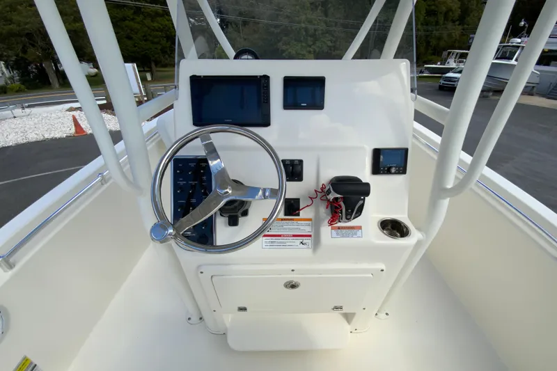 Slide: The Image of 2025 Cobia 220 Center Console boat dashboard with steering wheel and navigation controls. - 14