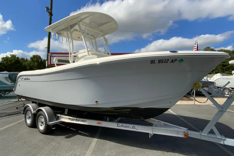 Slide: The Image of 2025 Cobia 220 Center Console boat on trailer under blue sky. - 2