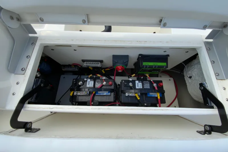 Slide: The Image of 2025 Cobia 220 Center Console boat battery compartment with wiring and components. - 20