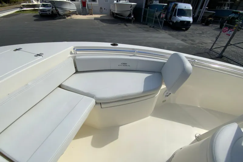 Slide: The Image of 2025 Cobia 220 Center Console boat interior with white cushioned seating. - 25