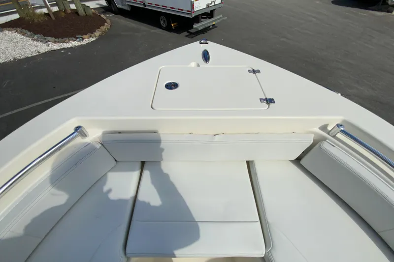 Slide: The Image of 2025 Cobia 220 Center Console boat interior with cushioned seating and storage compartment. - 26