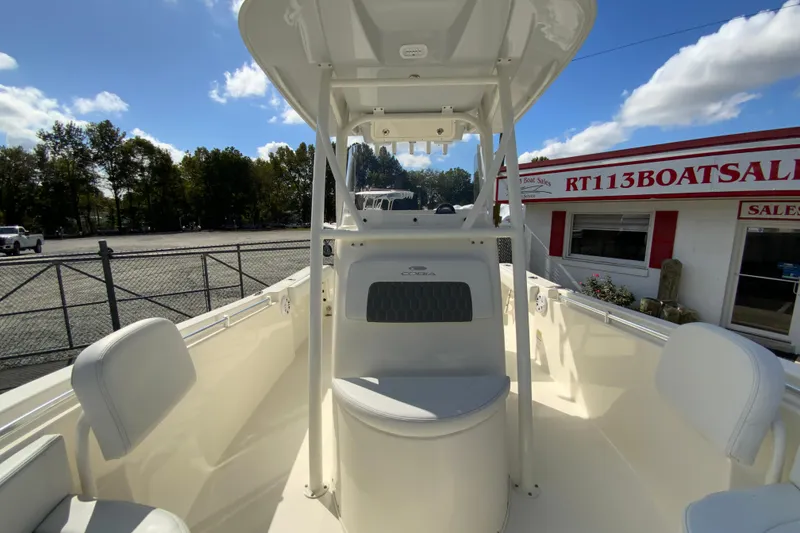 Slide: The Image of 2025 Cobia 220 Center Console boat at dealership, sunny day, clear sky. - 31