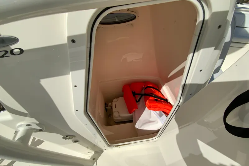 Slide: The Image of 2025 Cobia 220 Center Console storage compartment with life jackets and equipment. - 34