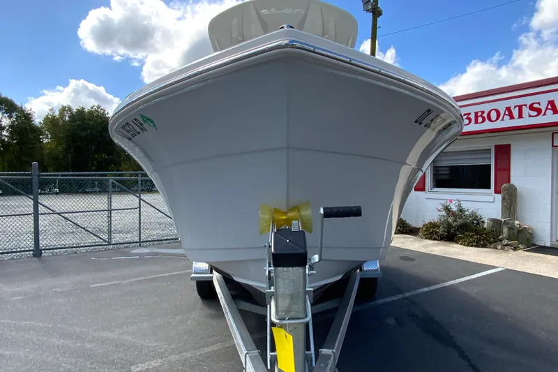 Slide: The Image of 2025 Cobia 220 Center Console boat on trailer, parked outside dealership. - 5
