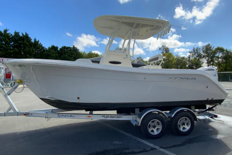 Slide: The Image of 2025 Cobia 220 Center Console boat on trailer under blue sky. - 7