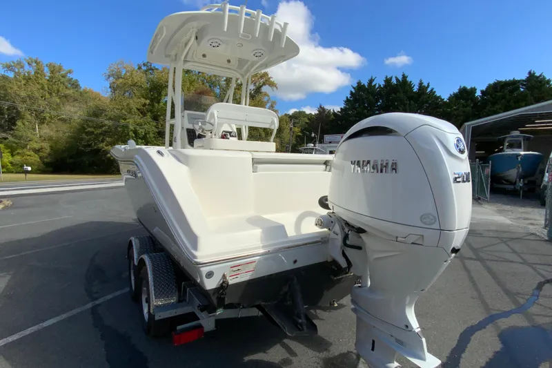 Slide: The Image of 2025 Cobia 220 Center Console boat with Yamaha 200 engine, parked outdoors. - 9