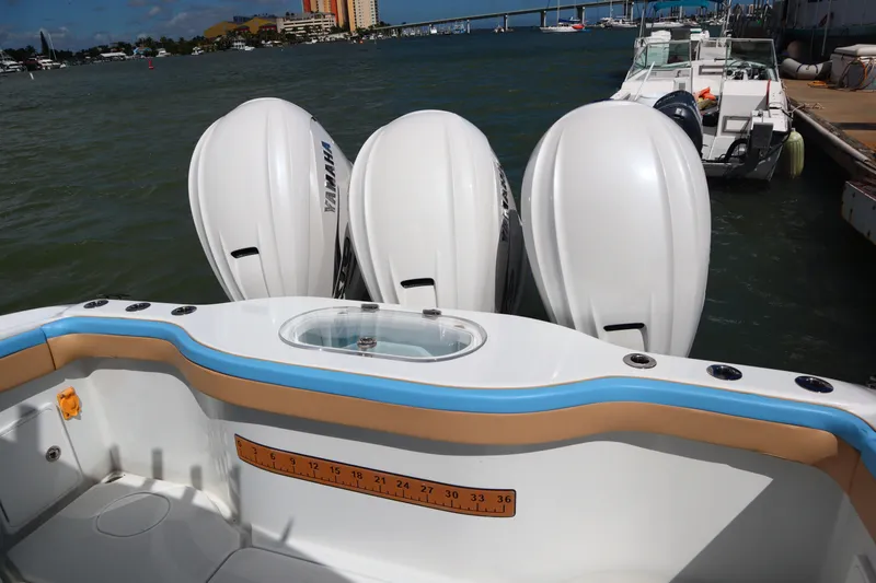 Slide: The Image of 2022 Yellowfin 42 Offshore boat with triple Yamaha outboard engines docked by the water. - 14