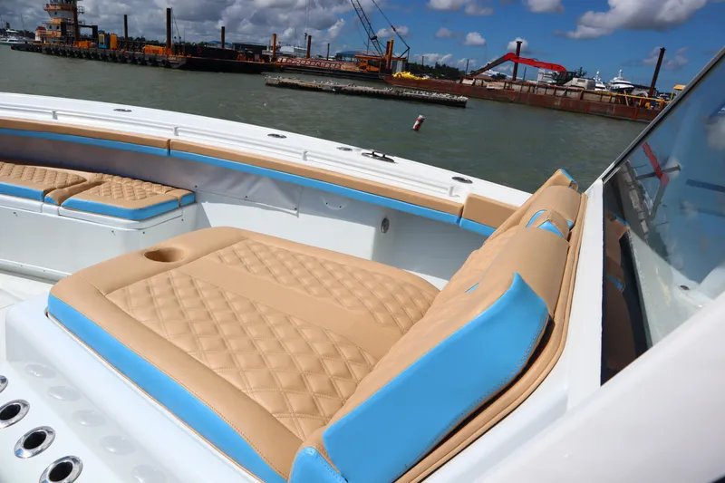 Slide: The Image of 2022 Yellowfin 42 Offshore boat with tan and blue seating, dockside view. - 16
