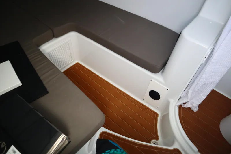 Slide: The Image of 2022 Yellowfin 42 Offshore cabin interior with brown flooring and cushioned seating. - 21