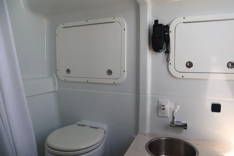 Slide: The Image of 2022 Yellowfin 42 Offshore boat bathroom with toilet, sink, and storage compartments. - 24