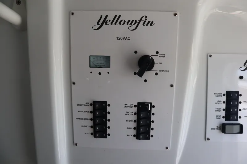 Slide: The Image of Control panel of a 2022 Yellowfin 42 Offshore boat, featuring power switches and gauges. - 25