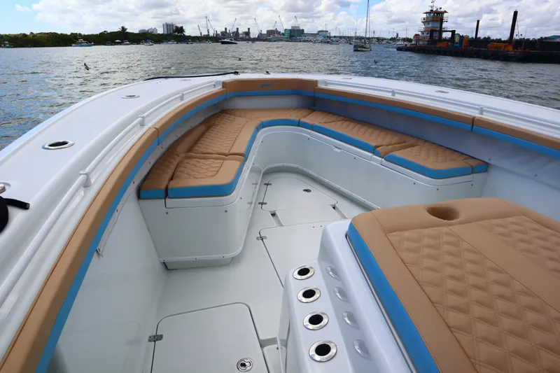 Slide: The Image of 2022 Yellowfin 42 Offshore boat with tan and blue seating, docked on a calm waterway. - 30