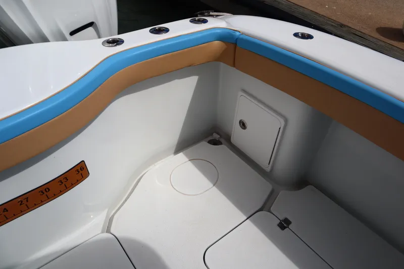 Slide: The Image of 2022 Yellowfin 42 Offshore boat interior with blue and tan accents, featuring a storage compartment. - 37