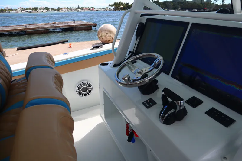 Slide: The Image of Interior of 2022 Yellowfin 42 Offshore boat with steering wheel and navigation screens. - 39