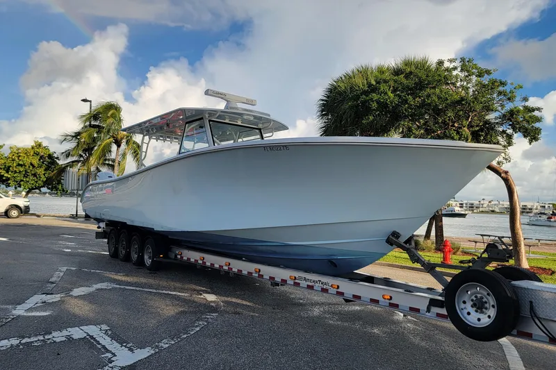 Slide: The Image of 2022 Yellowfin 42 Offshore boat on trailer by waterfront, under cloudy sky. - 5