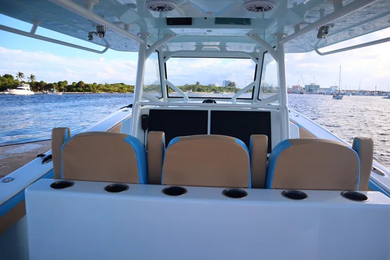 Slide: The Image of 2022 Yellowfin 42 Offshore boat interior with seating, overlooking a scenic waterfront. - 57