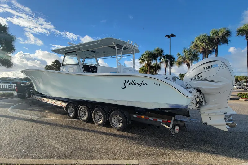 Slide: The Image of 2022 Yellowfin 42 Offshore boat on trailer, parked near palm trees under a blue sky. - 8