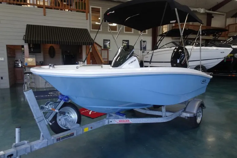 Slide: The Image of 2026 Boston Whaler 130 Super Sport boat on trailer in showroom. - 10