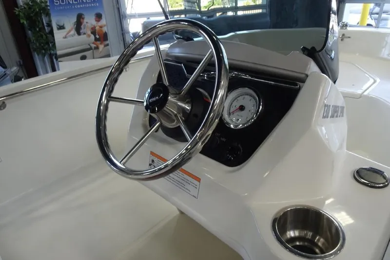 Slide: The Image of 2026 Boston Whaler 130 Super Sport boat steering console with chrome wheel and gauge. - 13