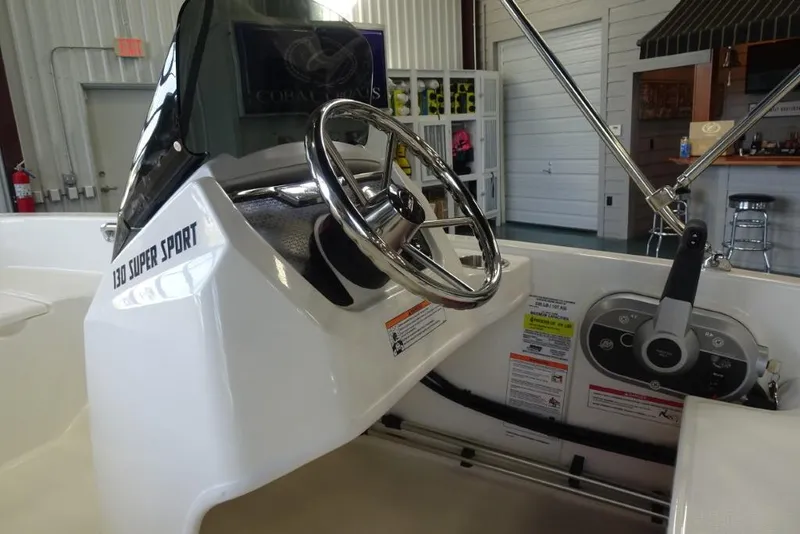 Slide: The Image of 2026 Boston Whaler 130 Super Sport boat interior with steering wheel and controls. - 15